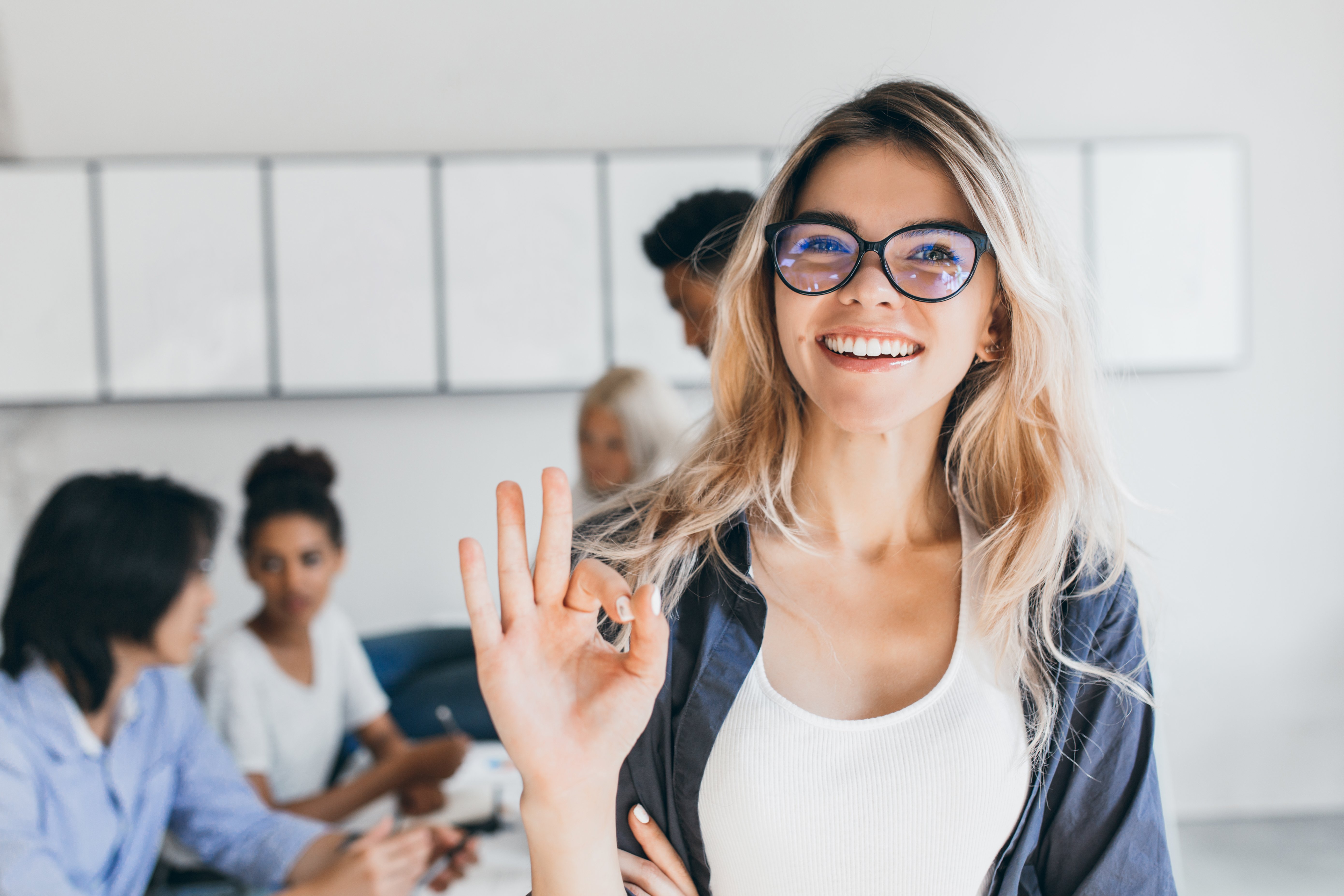 close-up-portrait-of-pretty-female-manager-from-sales-department-indoor-photo-of-smiling-woman-working-in-office-with-discussing-people